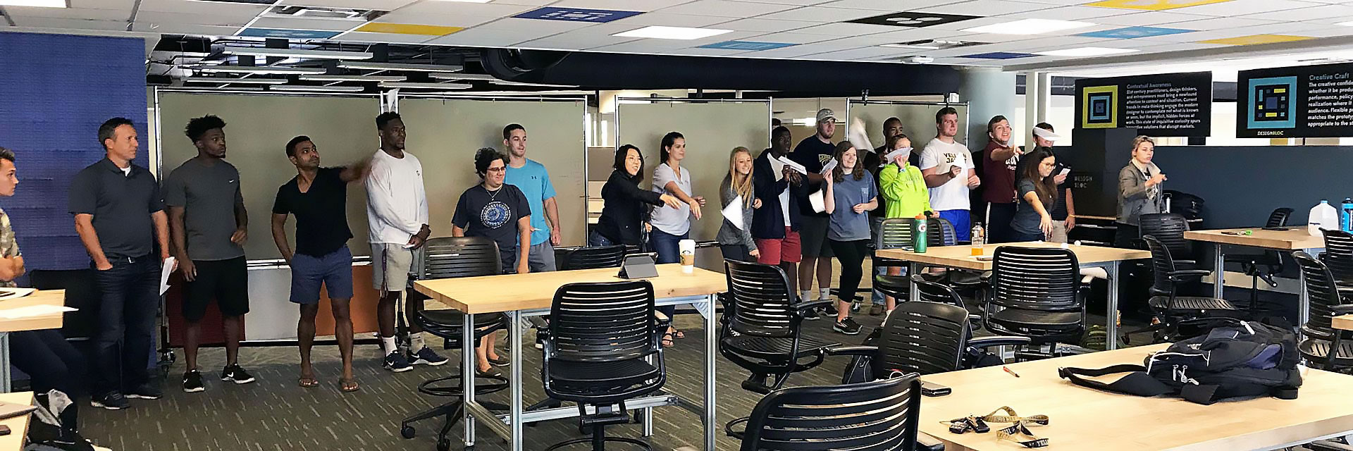 Participants in a Rapid Iteration workshop sail their paper airplanes across the classroom during one iteration of testing.